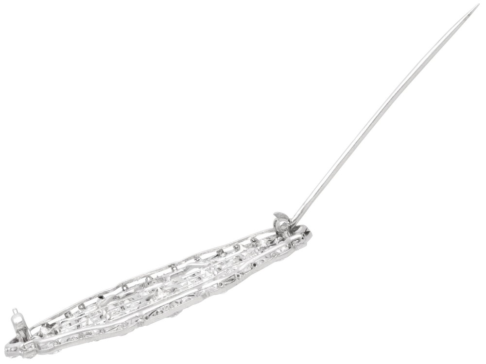 An Art Deco platinum brooch styled in an elongated geometric openwork plaque pattern, set throughout with brilliant and square-cut diamonds. View IX