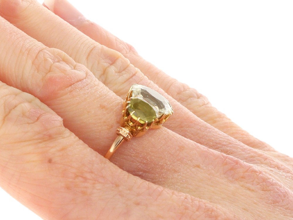 A late Victorian 18ct yellow gold trilogy ring featuring a central cushion-cut yellow sapphire flanked by two greenish-yellow chrysoberyl gemstones in claw settings. View XII