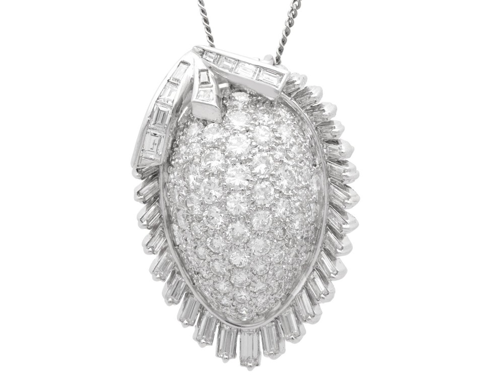 A 1950s vintage white gold organic pendant set with brilliant-cut diamonds and bordered by baguette-cut diamonds.