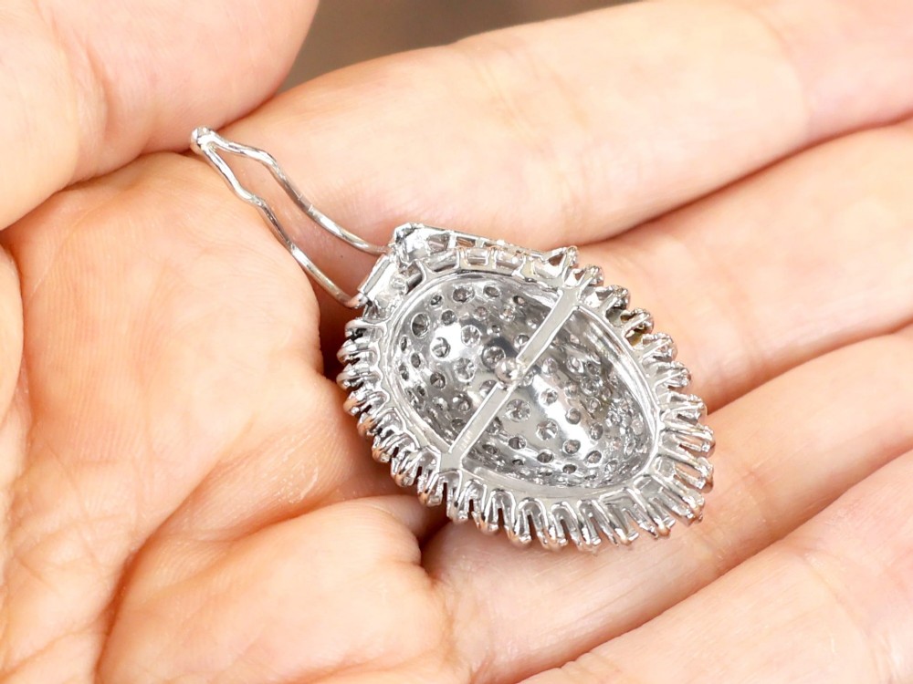 A 1950s vintage white gold organic pendant set with brilliant-cut diamonds and bordered by baguette-cut diamonds. View V