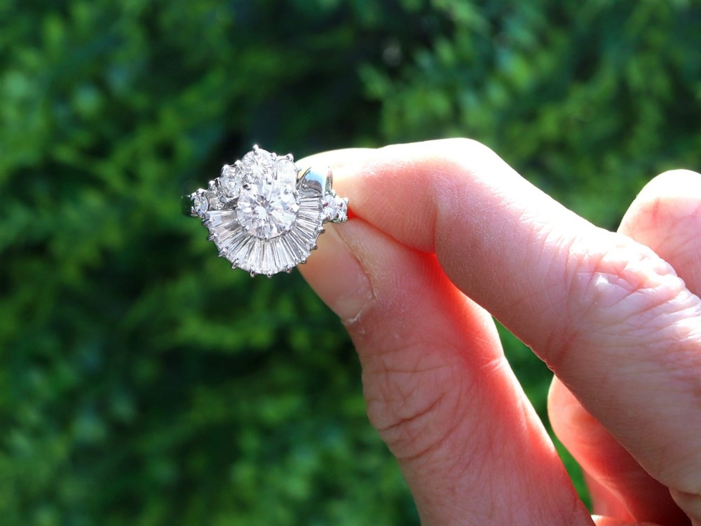 An 18ct white gold Art Deco cocktail ring featuring a central round diamond surrounded by a fan of baguette diamonds and accent round diamonds. View II