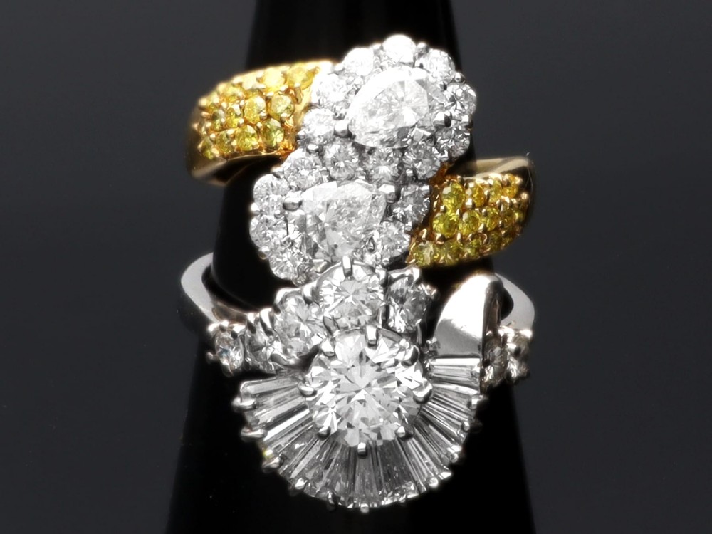 An 18ct white gold Art Deco cocktail ring featuring a central round diamond surrounded by a fan of baguette diamonds and accent round diamonds. View V