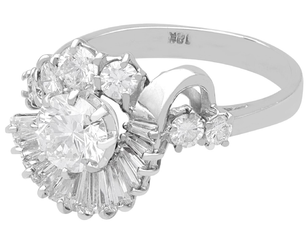 An 18ct white gold Art Deco cocktail ring featuring a central round diamond surrounded by a fan of baguette diamonds and accent round diamonds. View VII