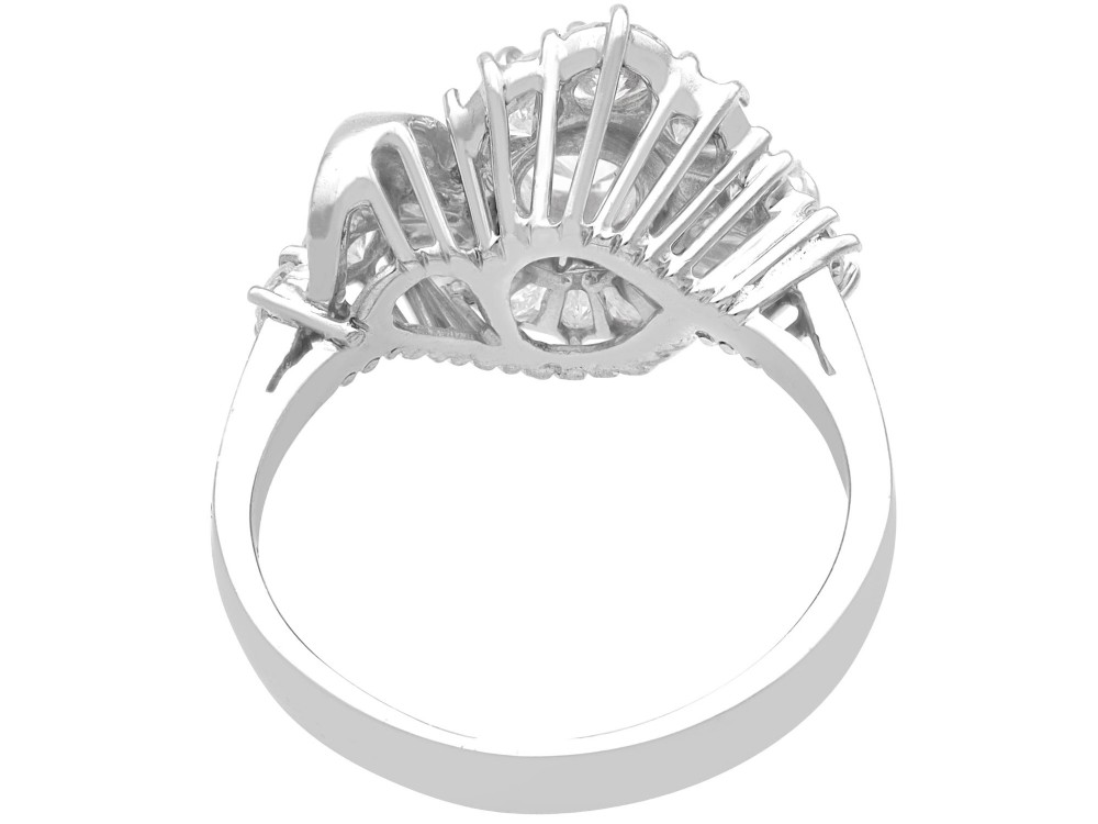 An 18ct white gold Art Deco cocktail ring featuring a central round diamond surrounded by a fan of baguette diamonds and accent round diamonds. View VIII
