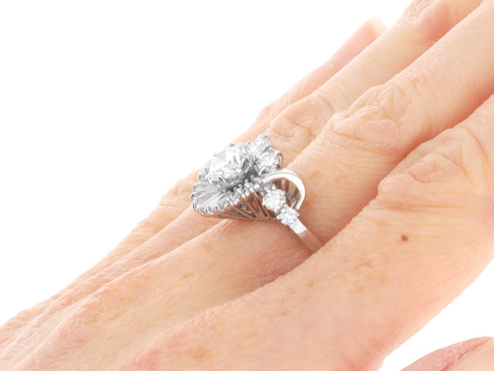 An 18ct white gold Art Deco cocktail ring featuring a central round diamond surrounded by a fan of baguette diamonds and accent round diamonds. View XI