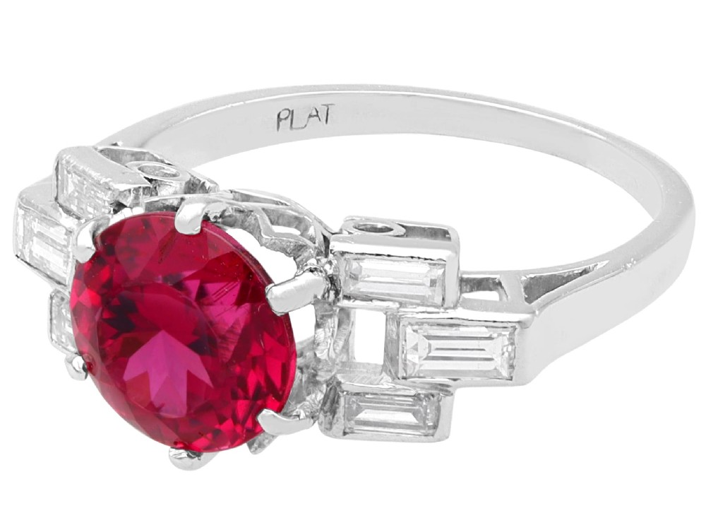 An Art Deco platinum ring featuring a round pink tourmaline centre stone set between stepped shoulders of baguette-cut diamonds. View VII