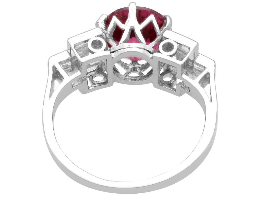 An Art Deco platinum ring featuring a round pink tourmaline centre stone set between stepped shoulders of baguette-cut diamonds. View VIII