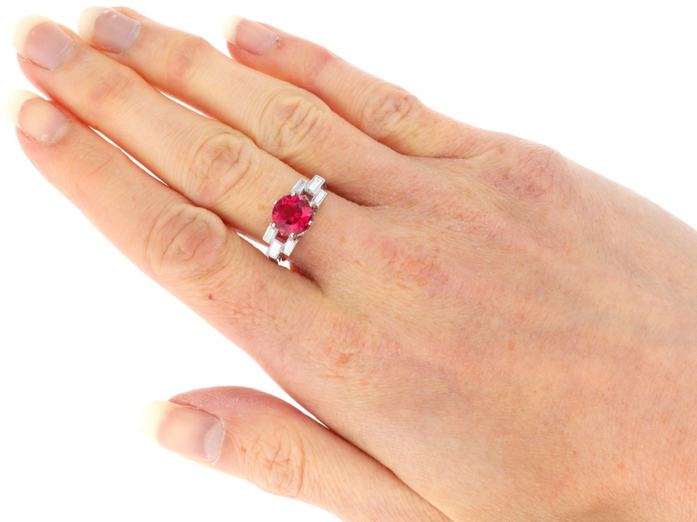 An Art Deco platinum ring featuring a round pink tourmaline centre stone set between stepped shoulders of baguette-cut diamonds. View XI
