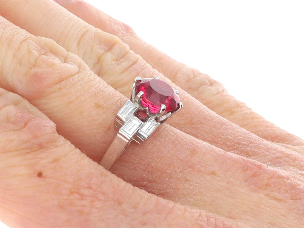 An Art Deco platinum ring featuring a round pink tourmaline centre stone set between stepped shoulders of baguette-cut diamonds. View XII