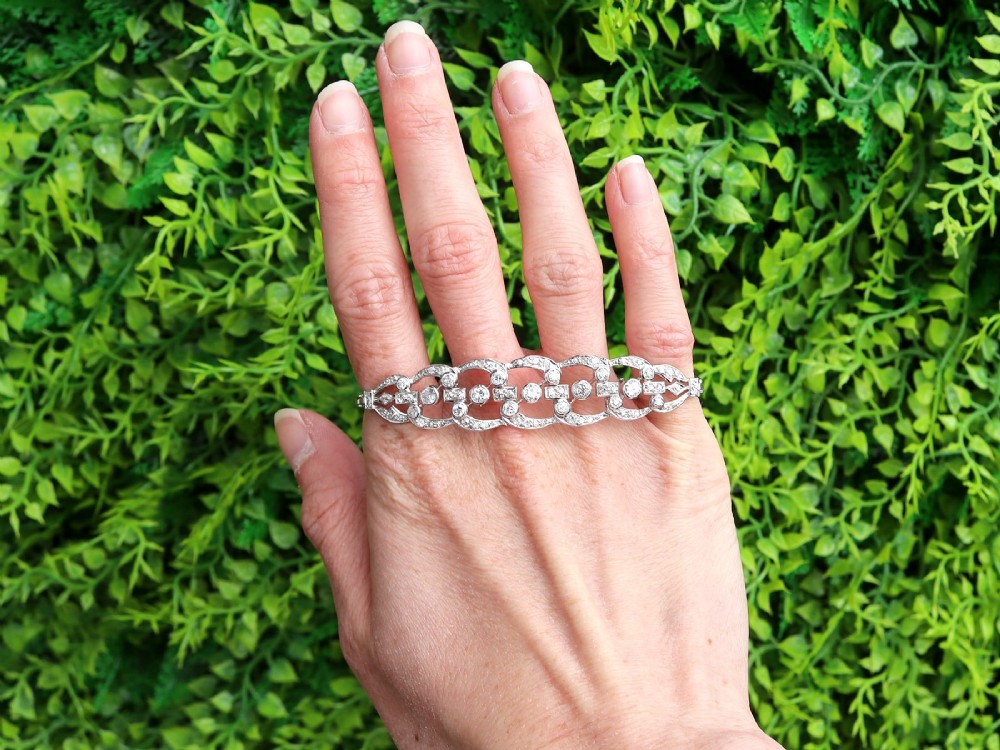 An Art Deco platinum bracelet featuring openwork geometric links set with round brilliant diamonds. View II