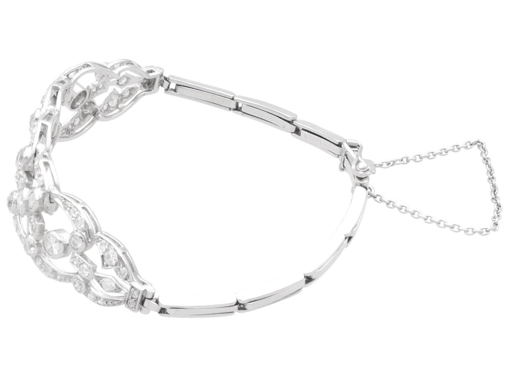 An Art Deco platinum bracelet featuring openwork geometric links set with round brilliant diamonds. View VII