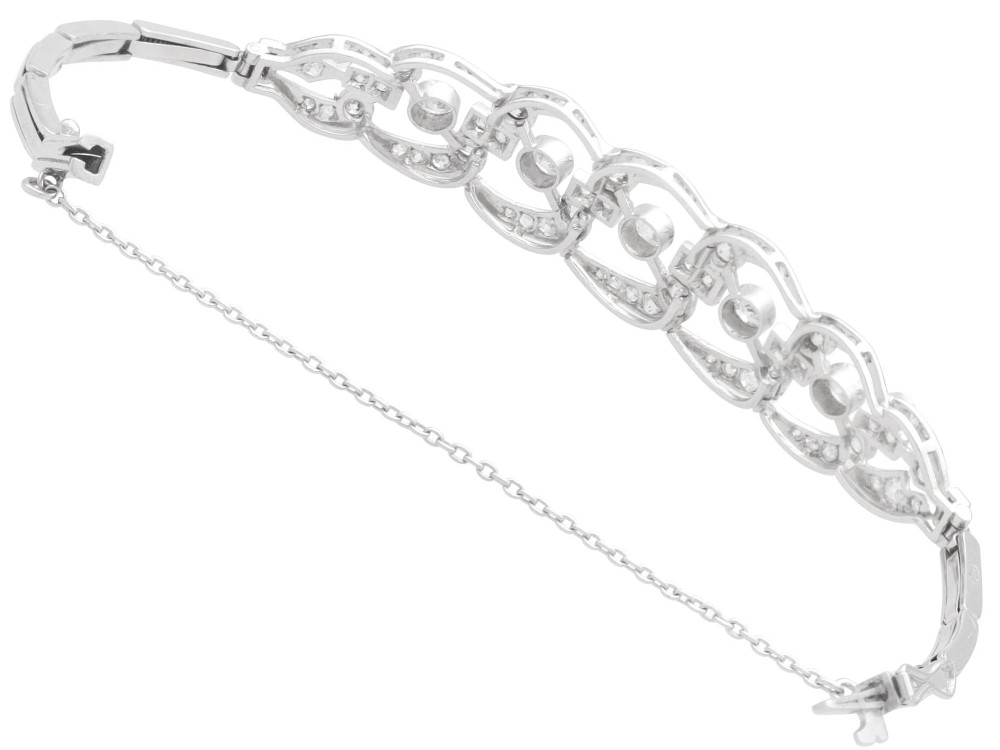 An Art Deco platinum bracelet featuring openwork geometric links set with round brilliant diamonds. View VIII