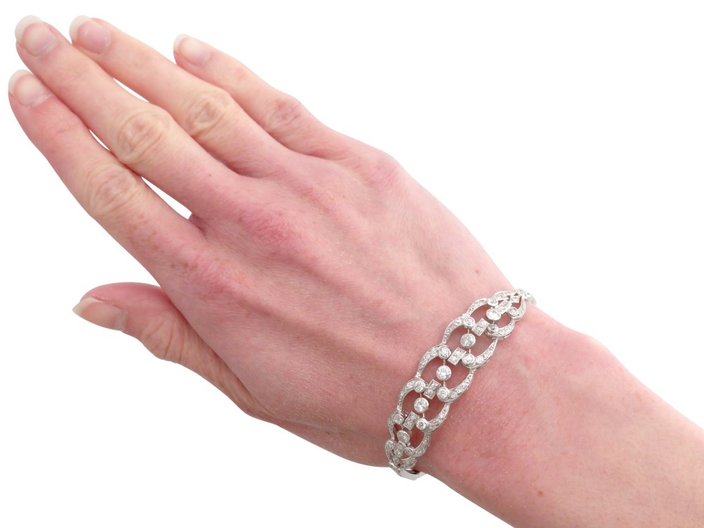 An Art Deco platinum bracelet featuring openwork geometric links set with round brilliant diamonds. View XI