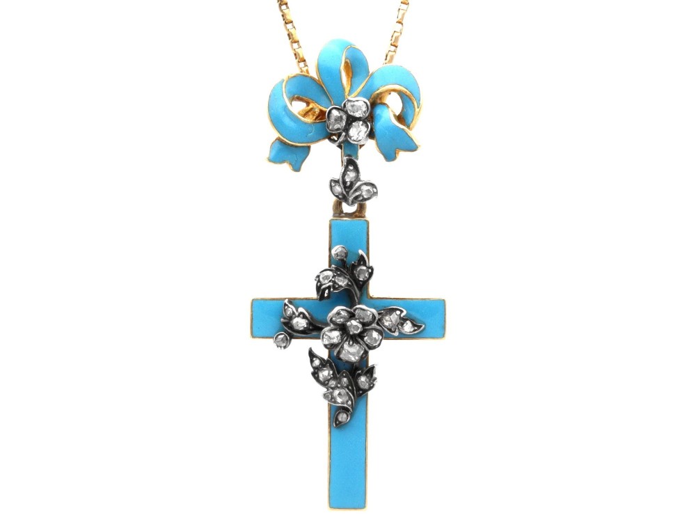 A Georgian 15ct yellow gold cross pendant featuring blue enamel, a diamond-set ribbon bow loop, and floral diamond overlays.