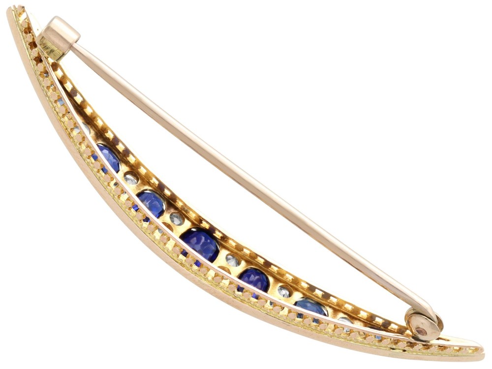 An antique late Victorian 9ct yellow gold crescent brooch set with graduated oval blue sapphires and accent diamonds. View VII
