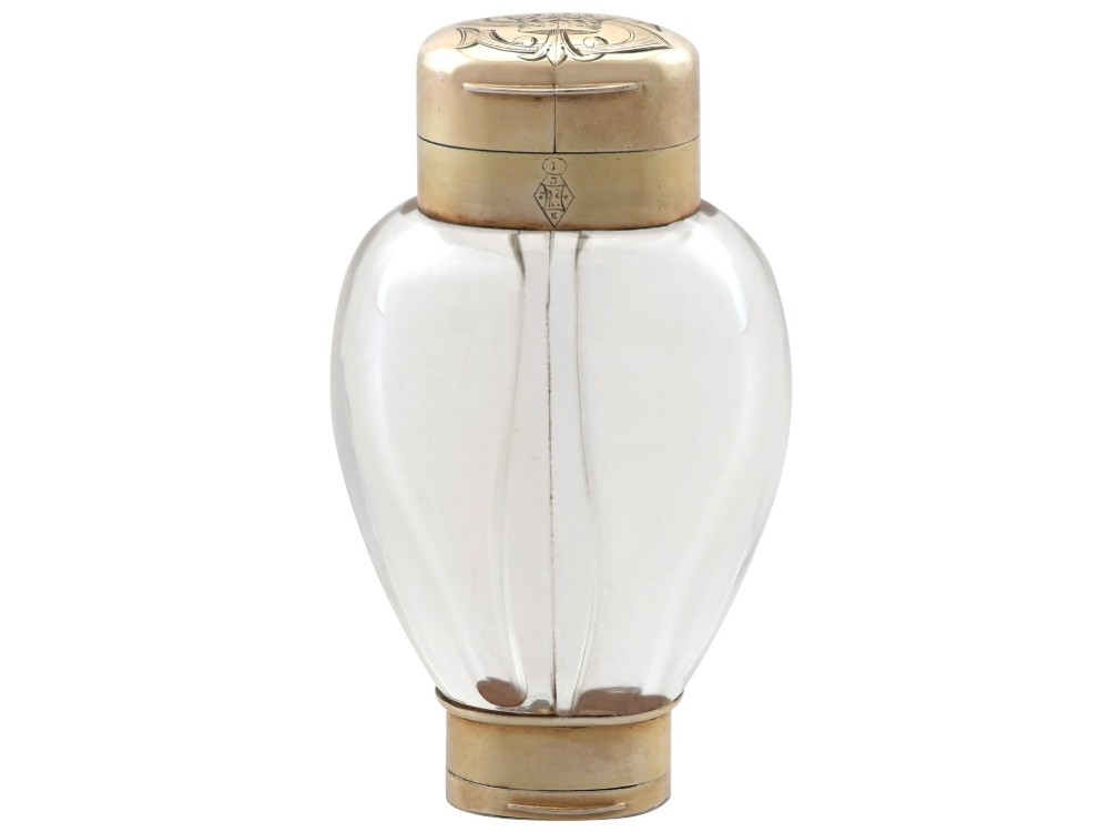 A Victorian clear glass scent bottle with fluted sides and engraved sterling silver caps at the top and base.