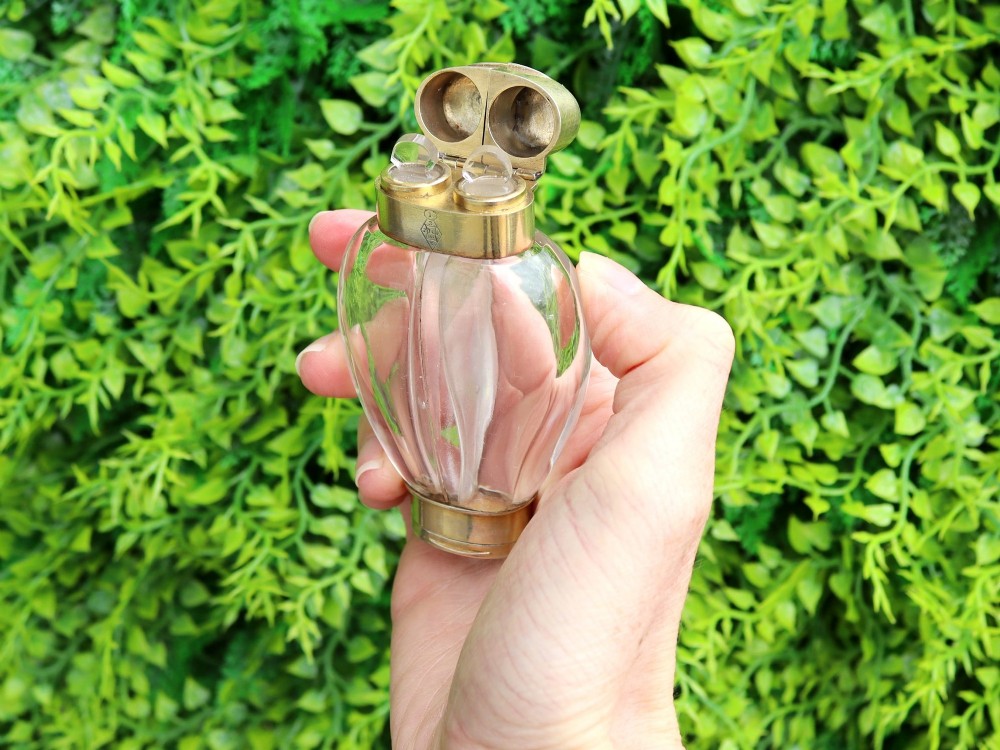 A Victorian clear glass scent bottle with fluted sides and engraved sterling silver caps at the top and base. View IV