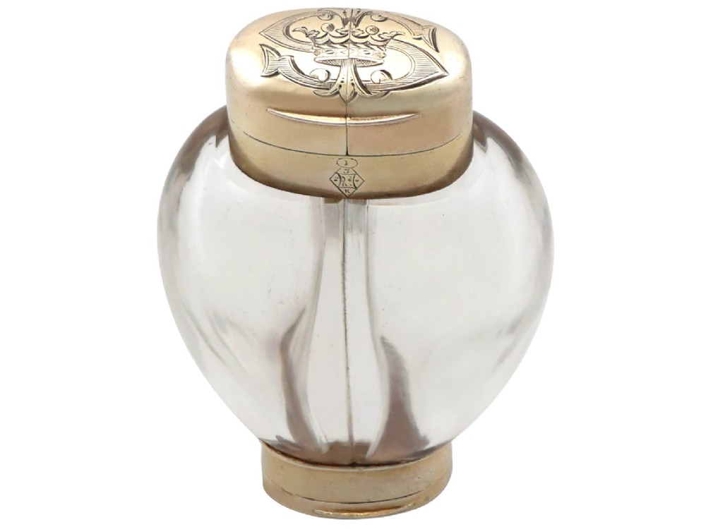 A Victorian clear glass scent bottle with fluted sides and engraved sterling silver caps at the top and base. View VII