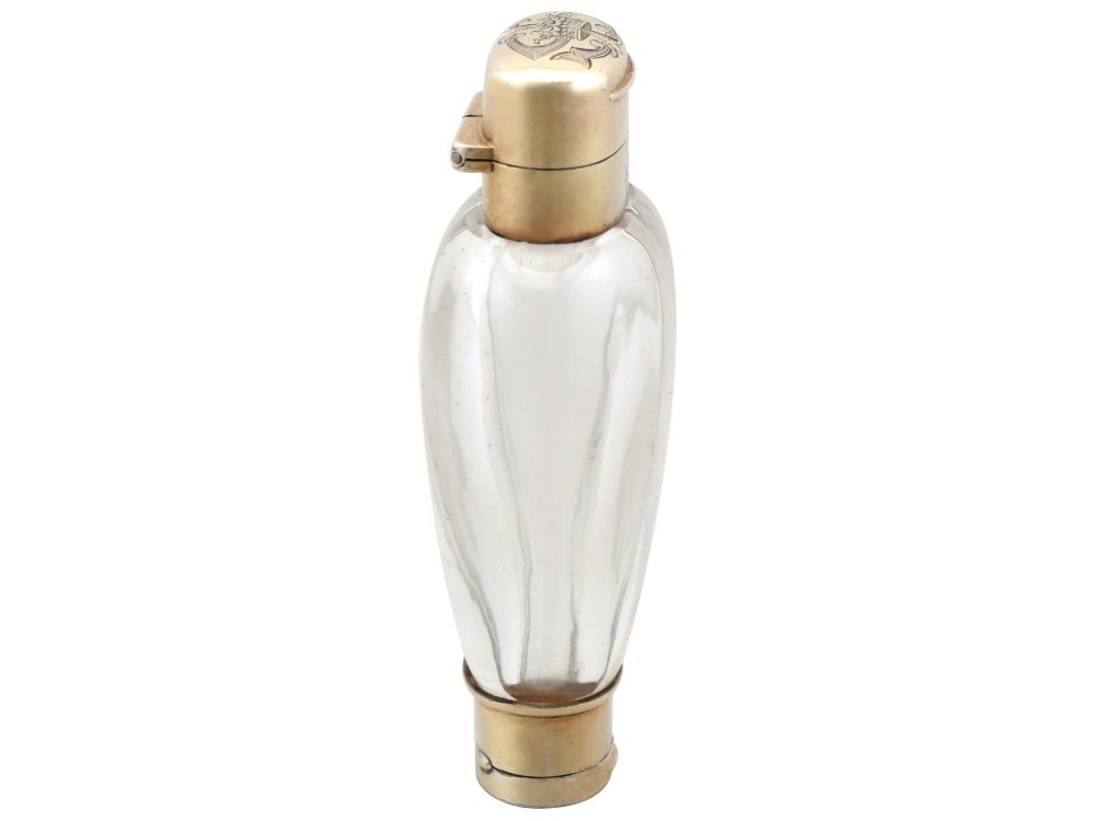 A Victorian clear glass scent bottle with fluted sides and engraved sterling silver caps at the top and base. View VIII