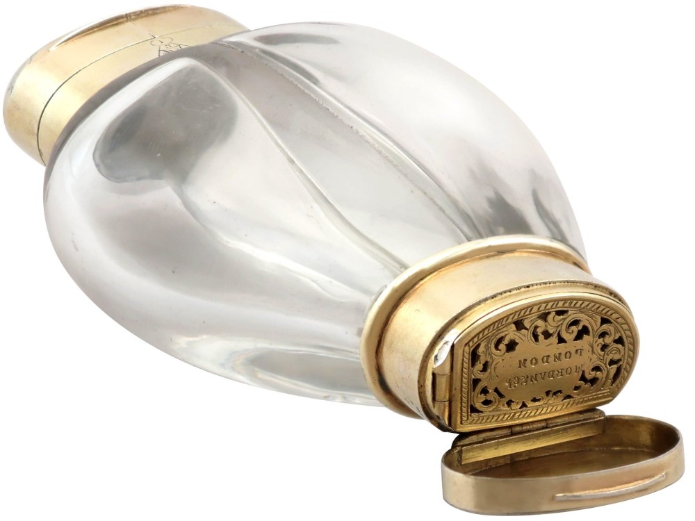 A Victorian clear glass scent bottle with fluted sides and engraved sterling silver caps at the top and base. View XI
