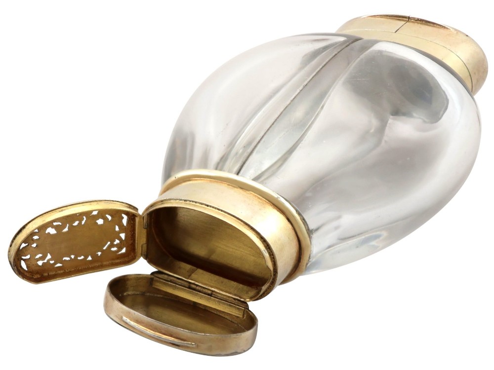A Victorian clear glass scent bottle with fluted sides and engraved sterling silver caps at the top and base. View XII