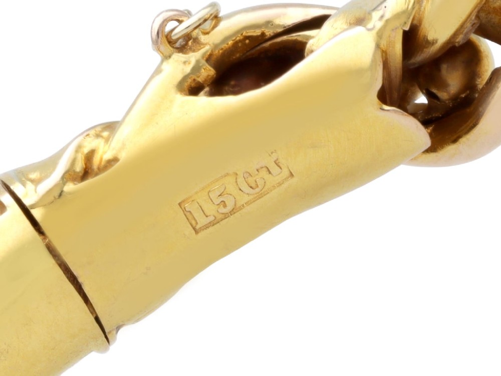 An antique Edwardian 15ct gold hinged bangle featuring a twisted ribbon design intertwined around a row of polished gold beads, fitted with a safety chain. View XII