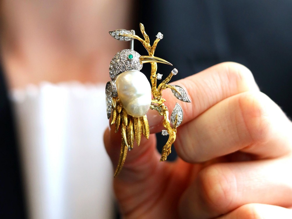 An antique 14ct gold bird brooch featuring a blister pearl body, pave diamond head with an emerald eye, perched on a textured gold branch. View III