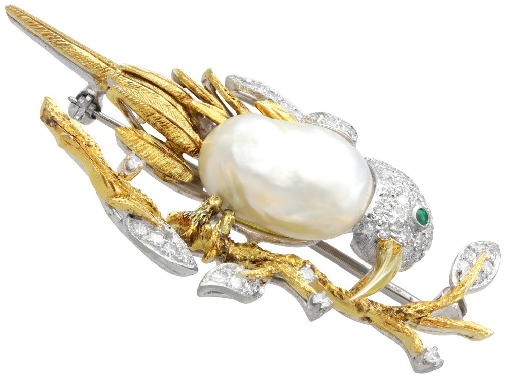 An antique 14ct gold bird brooch featuring a blister pearl body, pave diamond head with an emerald eye, perched on a textured gold branch. View VII