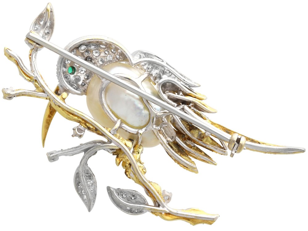 An antique 14ct gold bird brooch featuring a blister pearl body, pave diamond head with an emerald eye, perched on a textured gold branch. View VIII