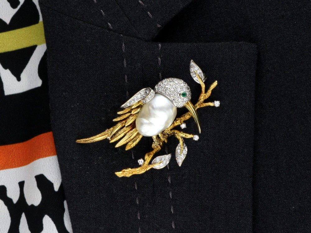 An antique 14ct gold bird brooch featuring a blister pearl body, pave diamond head with an emerald eye, perched on a textured gold branch. View XII