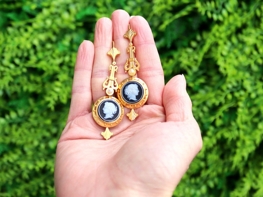 A pair of late Victorian 22ct yellow gold drop earrings featuring hand-carved hardstone cameo profile portraits and small seed pearls. View II