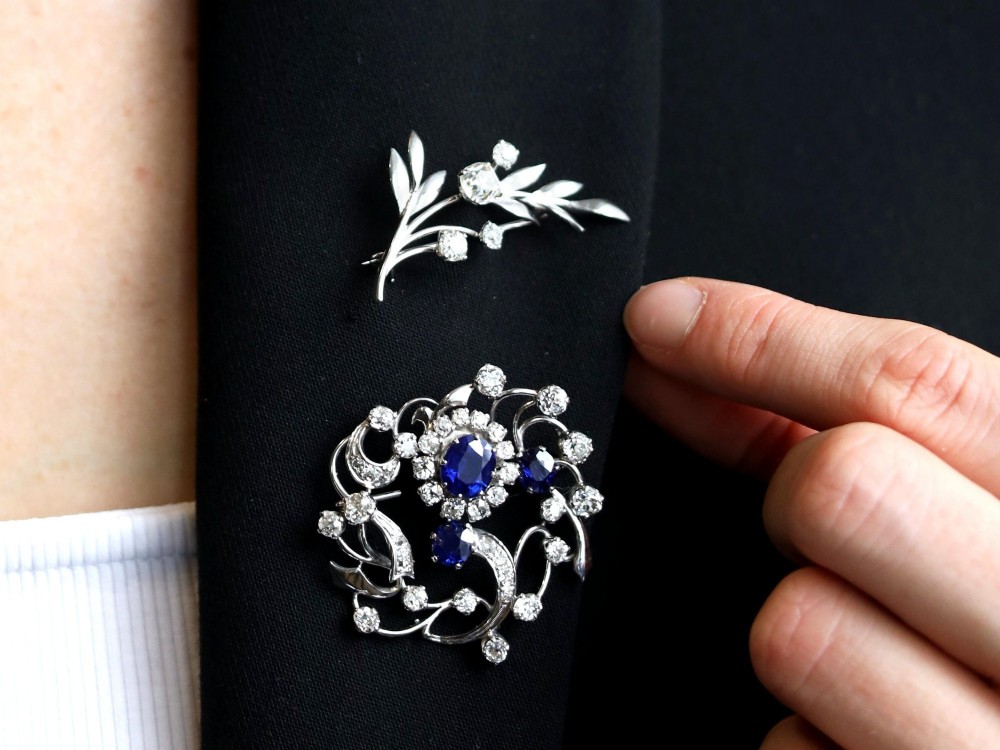 An 18ct white gold brooch crafted in the shape of a flowering spray, featuring leaf motifs and claw-set diamonds. View III