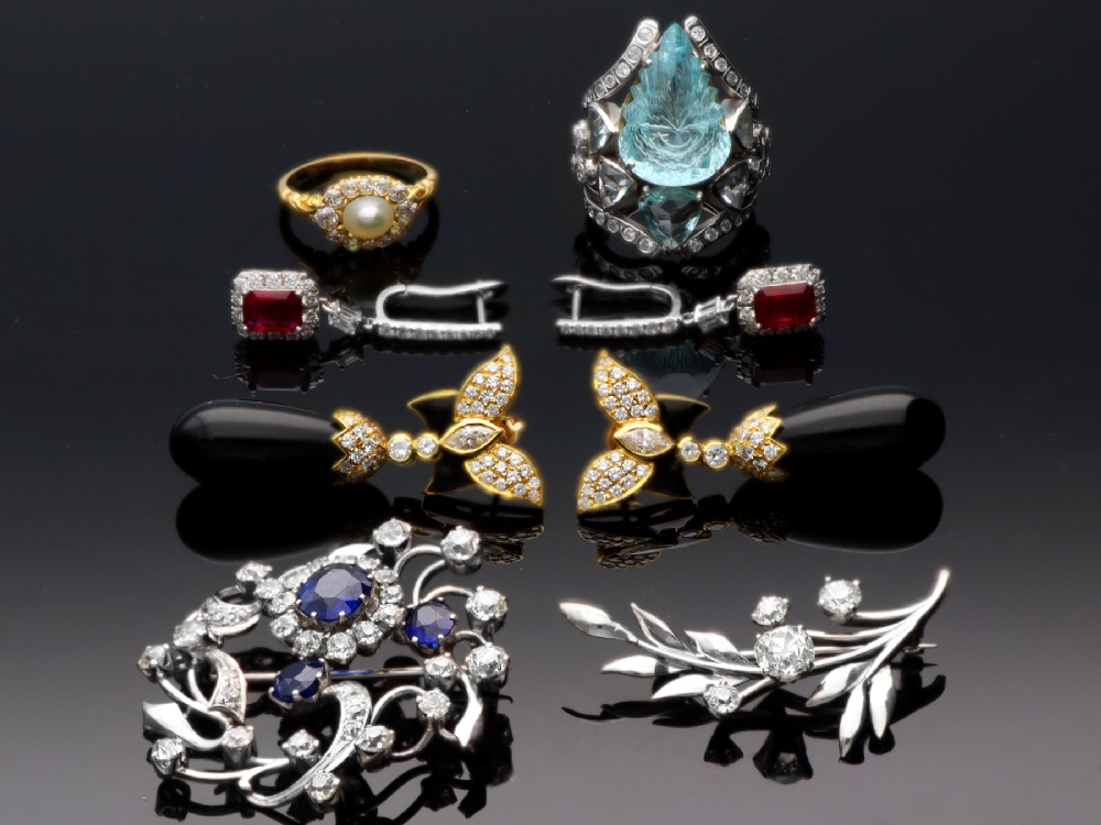 An 18ct white gold brooch crafted in the shape of a flowering spray, featuring leaf motifs and claw-set diamonds. View IV