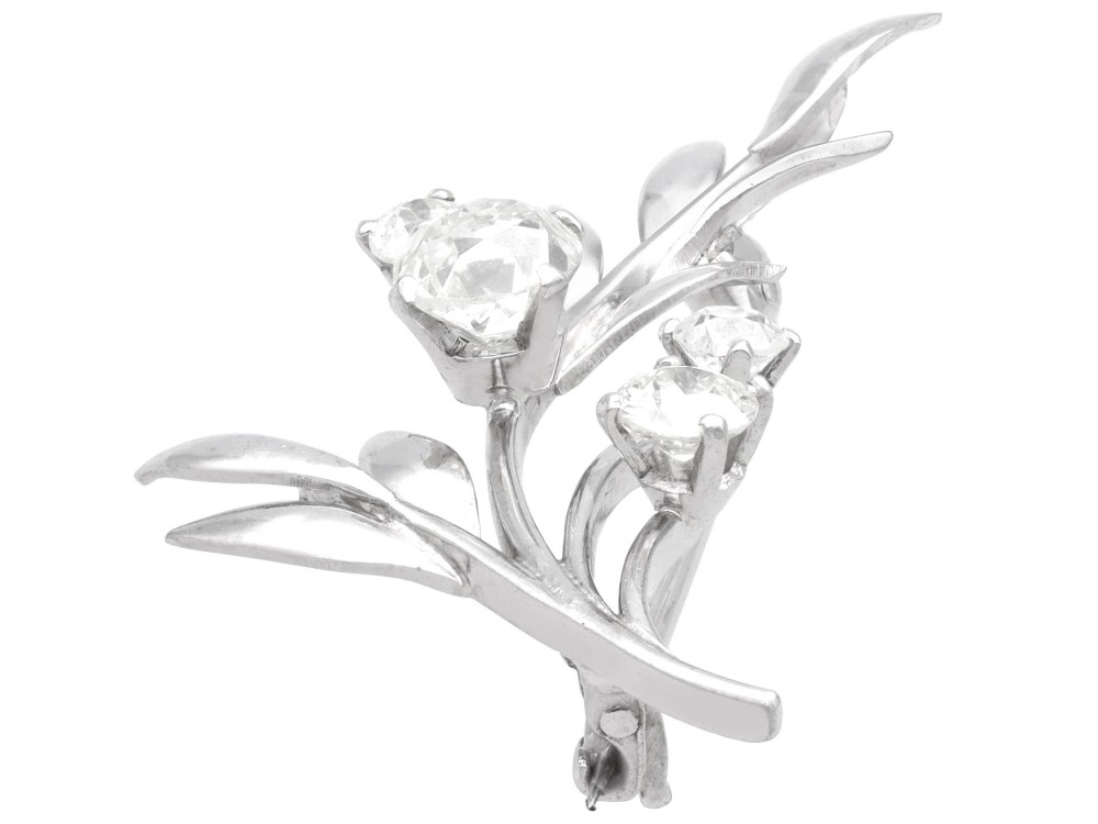 An 18ct white gold brooch crafted in the shape of a flowering spray, featuring leaf motifs and claw-set diamonds. View V