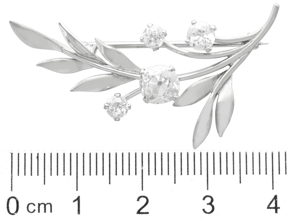 An 18ct white gold brooch crafted in the shape of a flowering spray, featuring leaf motifs and claw-set diamonds. View VIII