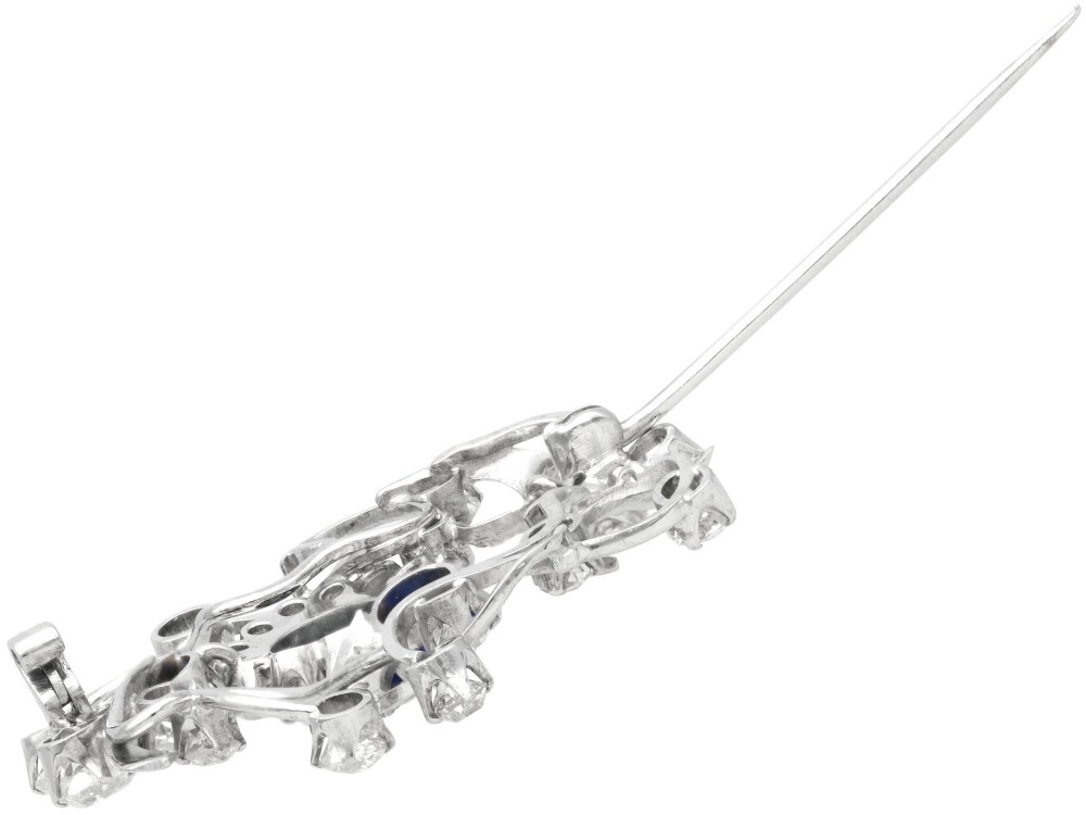 An Edwardian 18ct white gold brooch set with three oval blue sapphires surrounded by openwork diamond-set scrollwork. View VIII