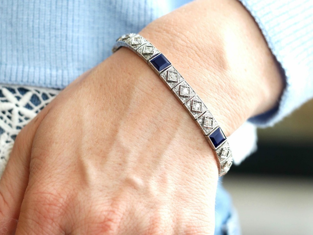 An Art Deco platinum bracelet featuring square basaltic blue sapphires and diamond-shaped link panels set with old-cut diamonds. View III