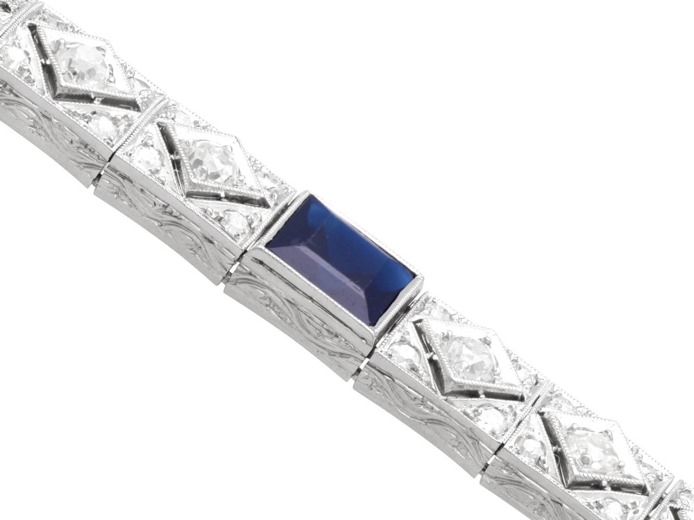 An Art Deco platinum bracelet featuring square basaltic blue sapphires and diamond-shaped link panels set with old-cut diamonds. View VII