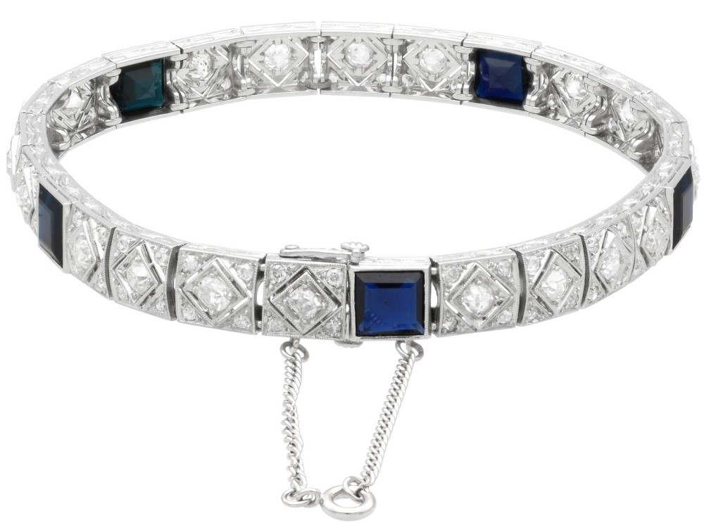 An Art Deco platinum bracelet featuring square basaltic blue sapphires and diamond-shaped link panels set with old-cut diamonds. View IX