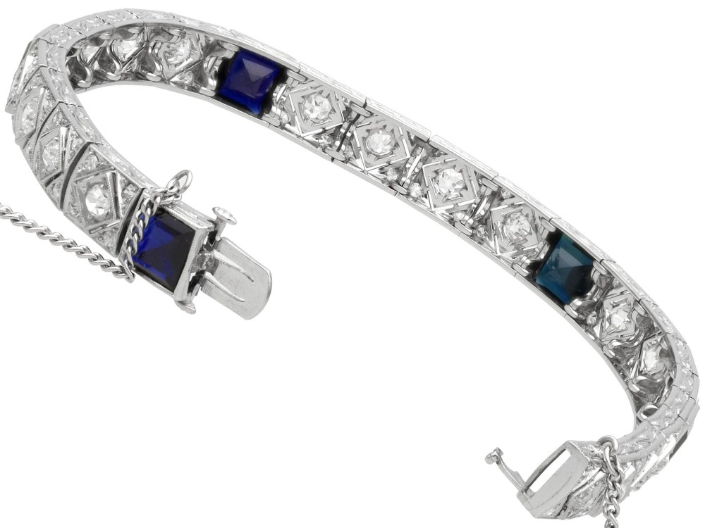 An Art Deco platinum bracelet featuring square basaltic blue sapphires and diamond-shaped link panels set with old-cut diamonds. View X