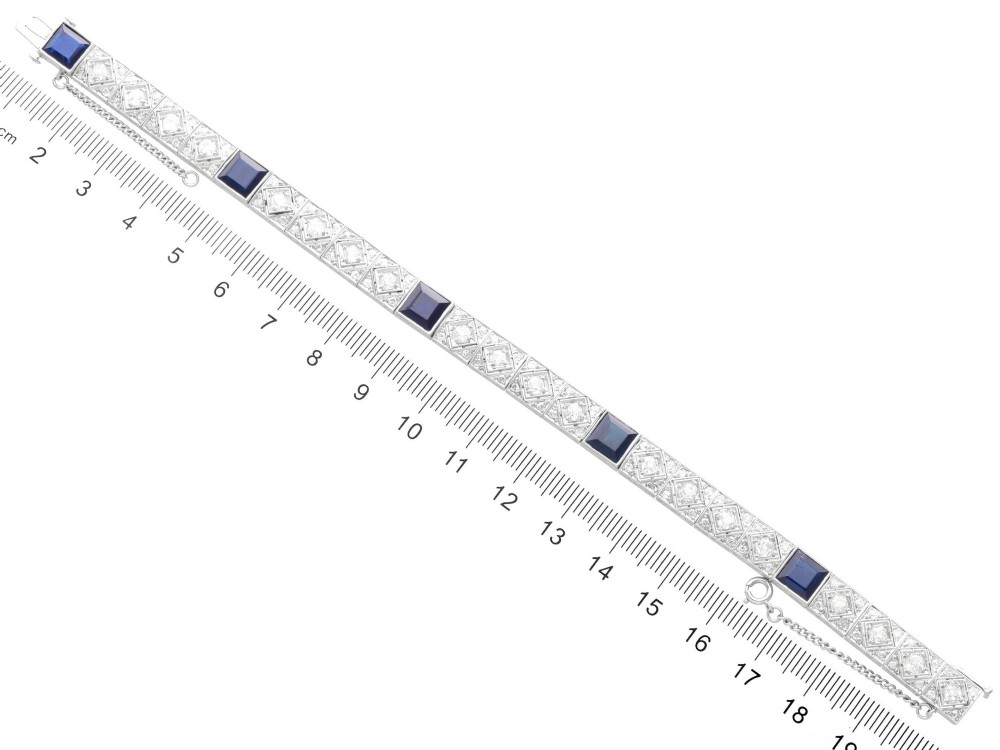 An Art Deco platinum bracelet featuring square basaltic blue sapphires and diamond-shaped link panels set with old-cut diamonds. View XI