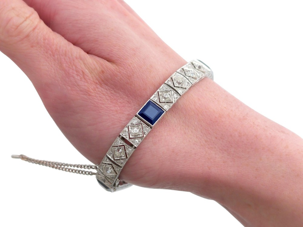 An Art Deco platinum bracelet featuring square basaltic blue sapphires and diamond-shaped link panels set with old-cut diamonds. View XII