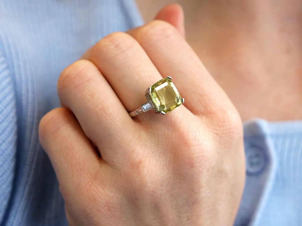 An Art Deco platinum ring featuring a large cushion cut yellow chrysoberyl central gemstone flanked by step cut diamonds on the shoulders. View III