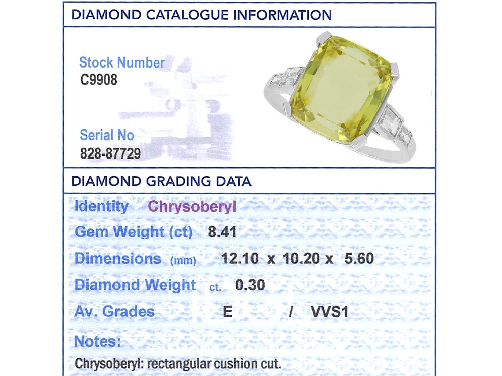 An Art Deco platinum ring featuring a large cushion cut yellow chrysoberyl central gemstone flanked by step cut diamonds on the shoulders. View XI