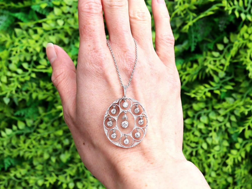 An Art Deco circular platinum pendant featuring openwork wirework circles set with diamonds, suspended from a fine chain. View II