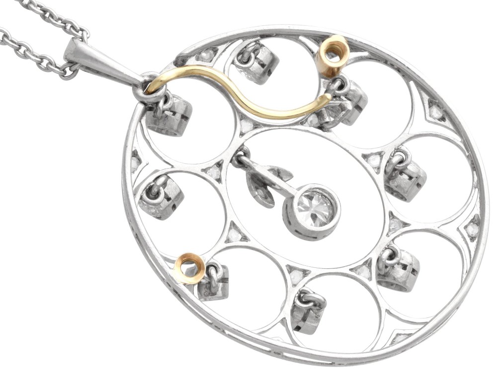 An Art Deco circular platinum pendant featuring openwork wirework circles set with diamonds, suspended from a fine chain. View VII