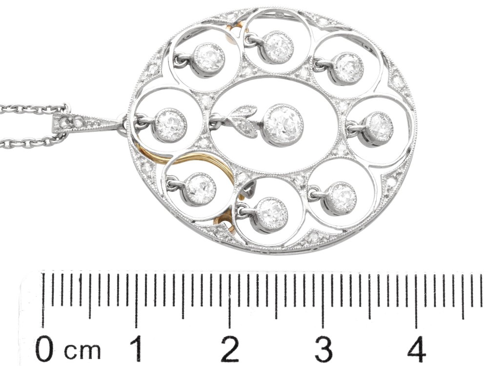 An Art Deco circular platinum pendant featuring openwork wirework circles set with diamonds, suspended from a fine chain. View VIII