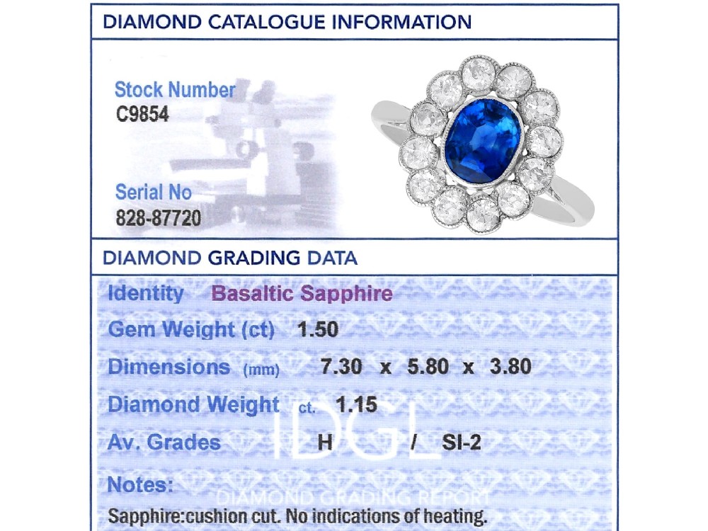 An antique platinum cluster ring featuring a central oval blue sapphire framed by twelve round cut diamonds with millegrain detail. View XIII