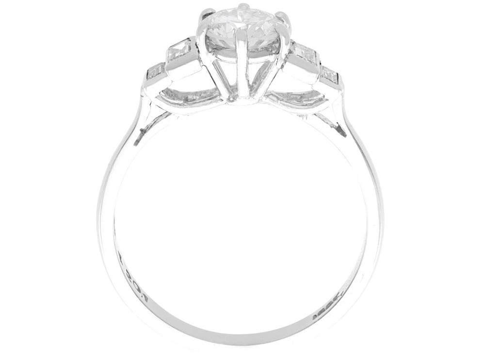 An 18ct white gold Art Deco ring featuring a central round diamond flanked by stepped baguette diamond shoulders. View VI