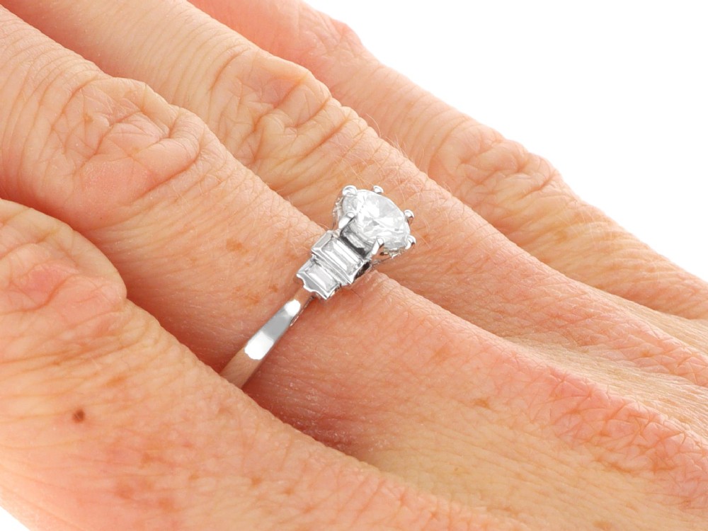 An 18ct white gold Art Deco ring featuring a central round diamond flanked by stepped baguette diamond shoulders. View VIII